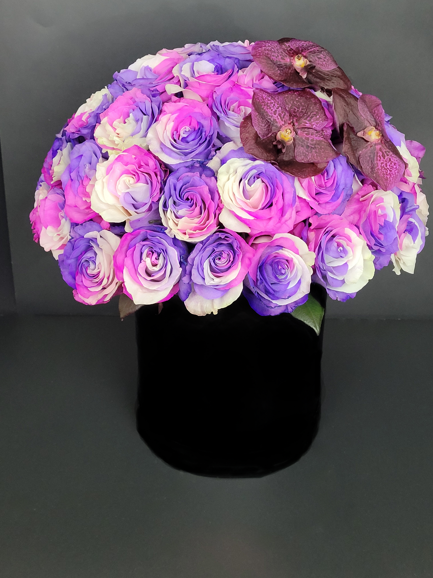 Dyed roses and Vanda orchids in black box