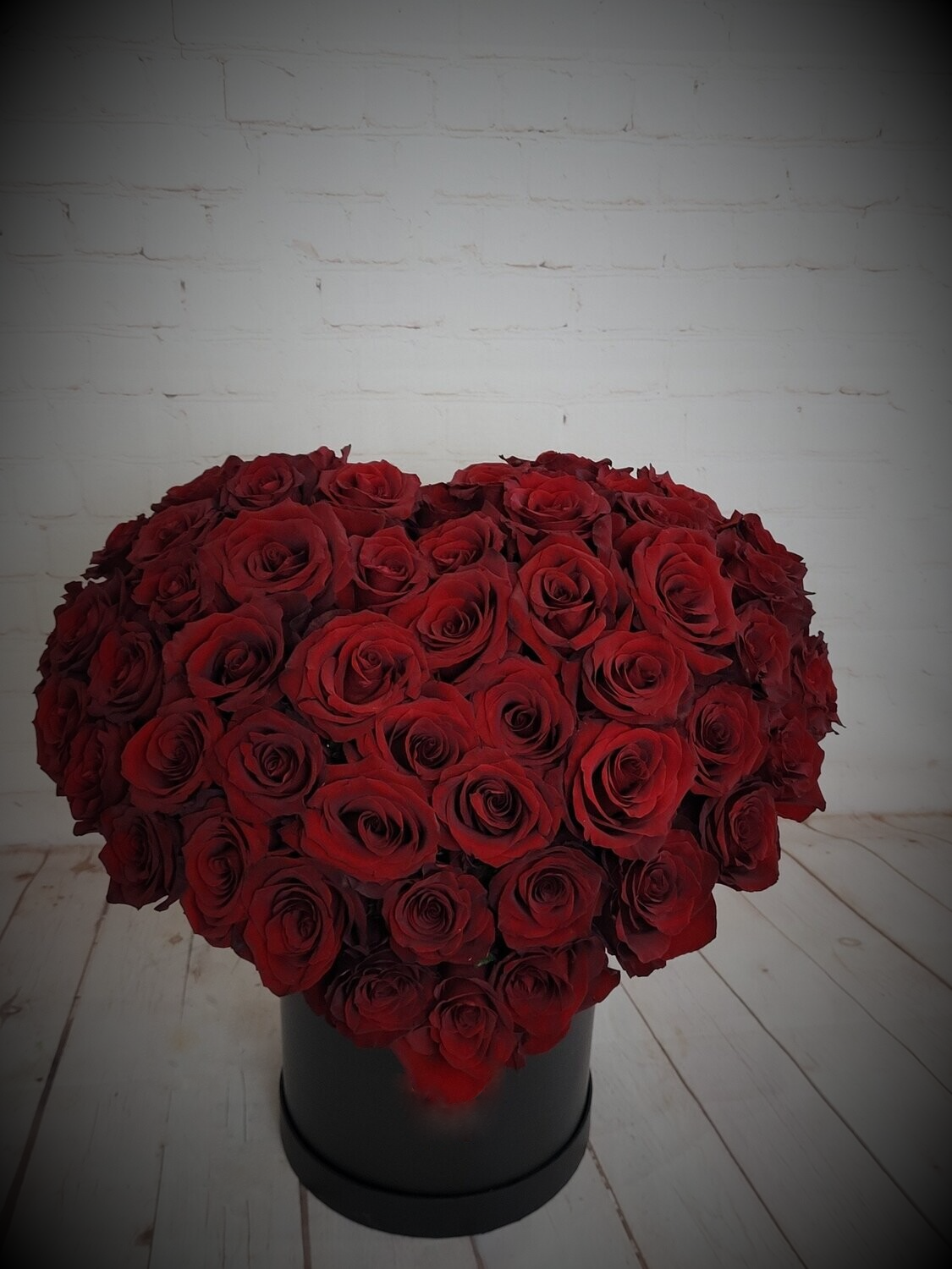 Red roses arranged in heart shape in a box