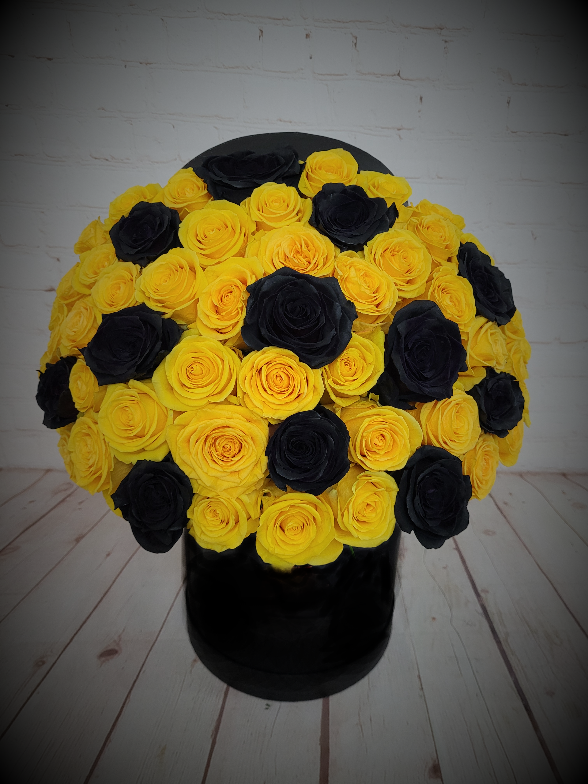Yellow and black roses in a box