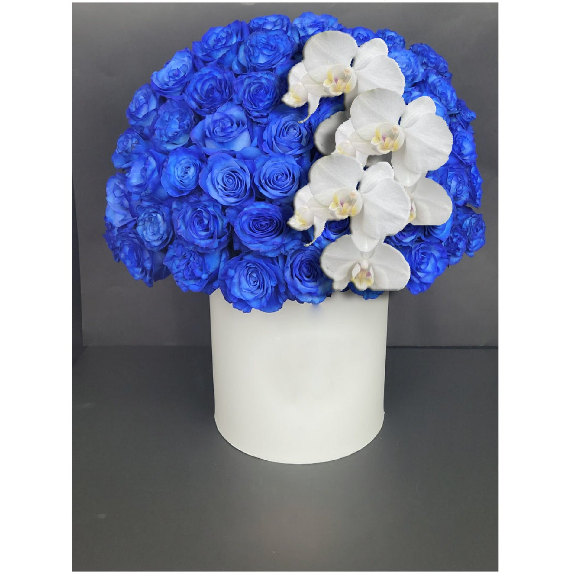 Blue roses and white orchids in white box